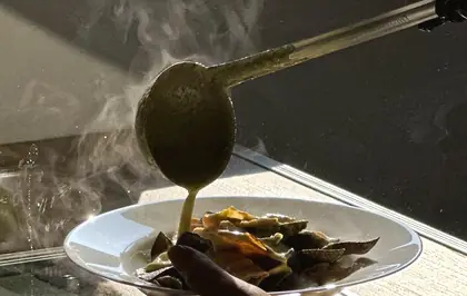 Un cucharón sirve caldo sobre un plato en una estación de TEMPO, en otro evento.