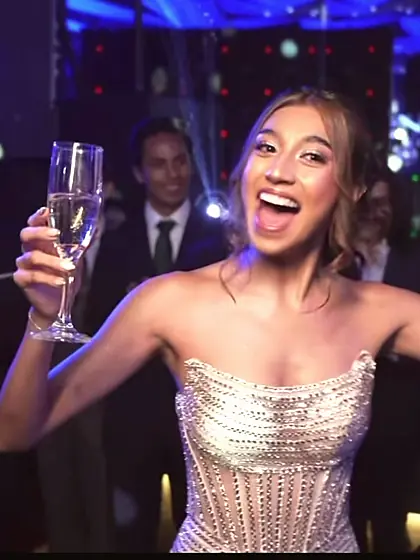 Una invitada brinda con una copa en la pista, en otro evento de Julieta.
