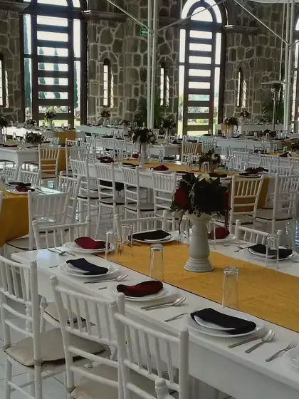 Una sede montada con mesas largas y sillas blancas, en otro evento de TEMPO.