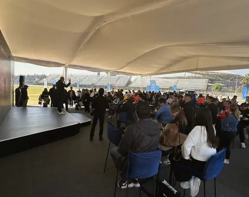 Invitados frente al escenario bajo una carpa, en otro evento de TEMPO.